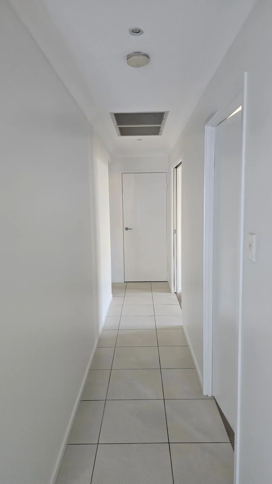 Freshly painted white hallway and door with protective coverings removed
