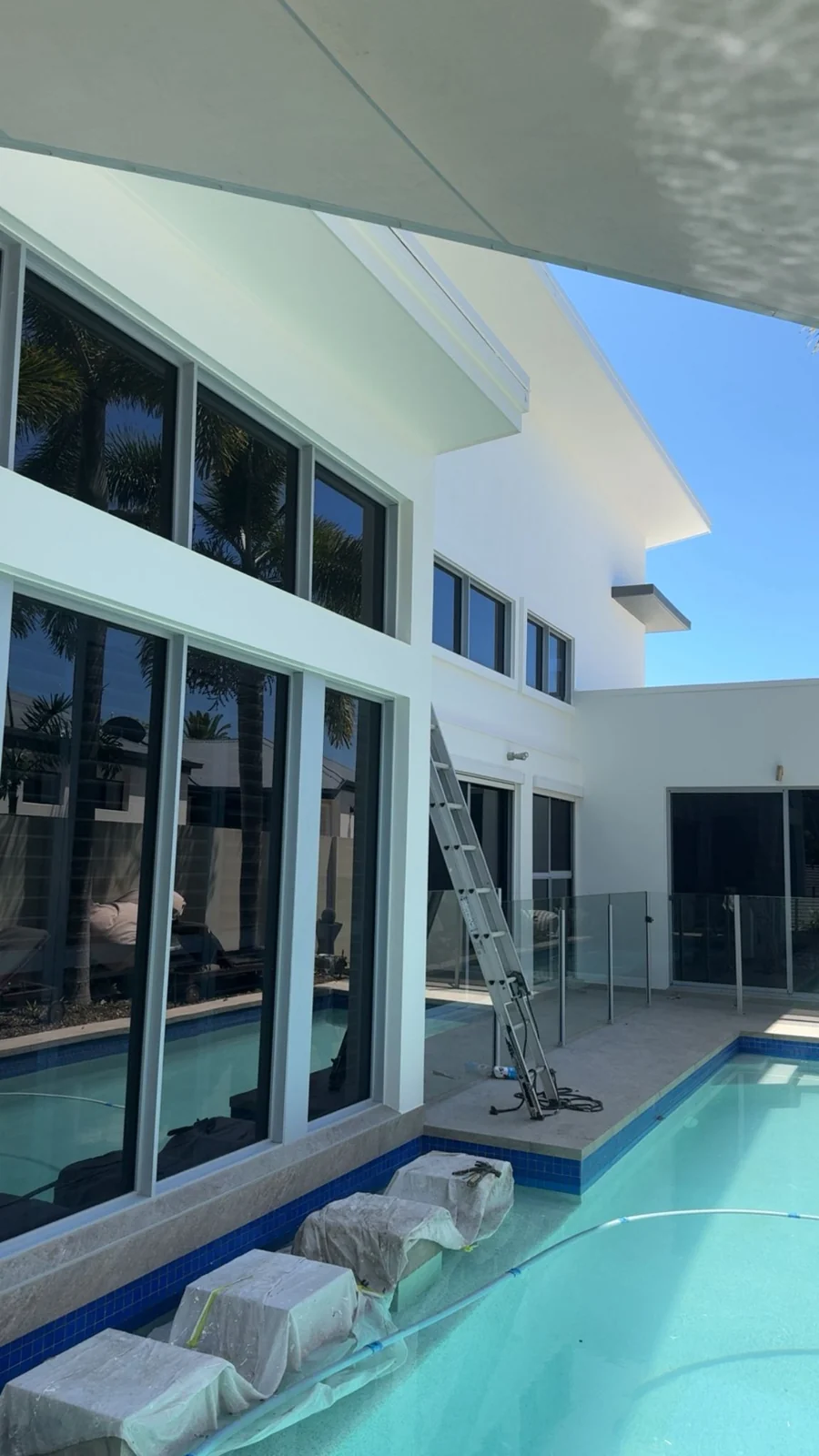 Exterior repaint work around a modern home and pool