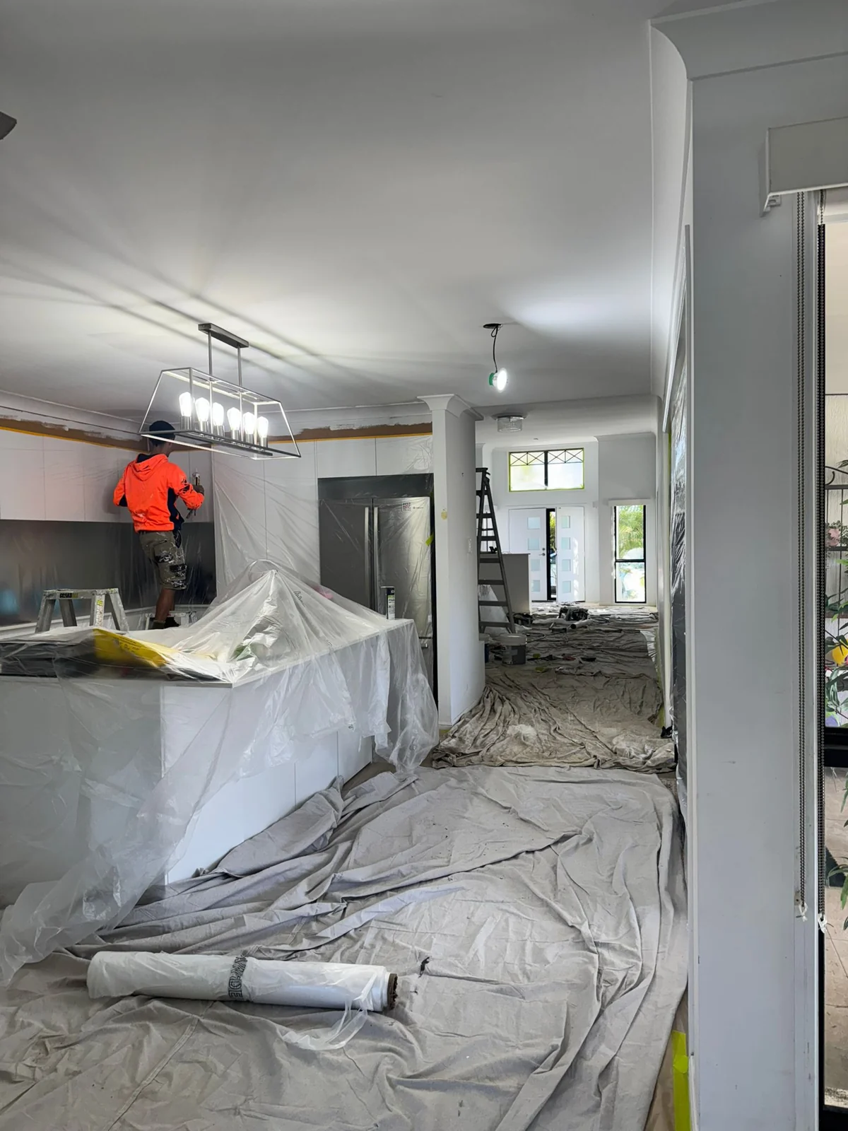 Covered kitchen and living room during interior painting