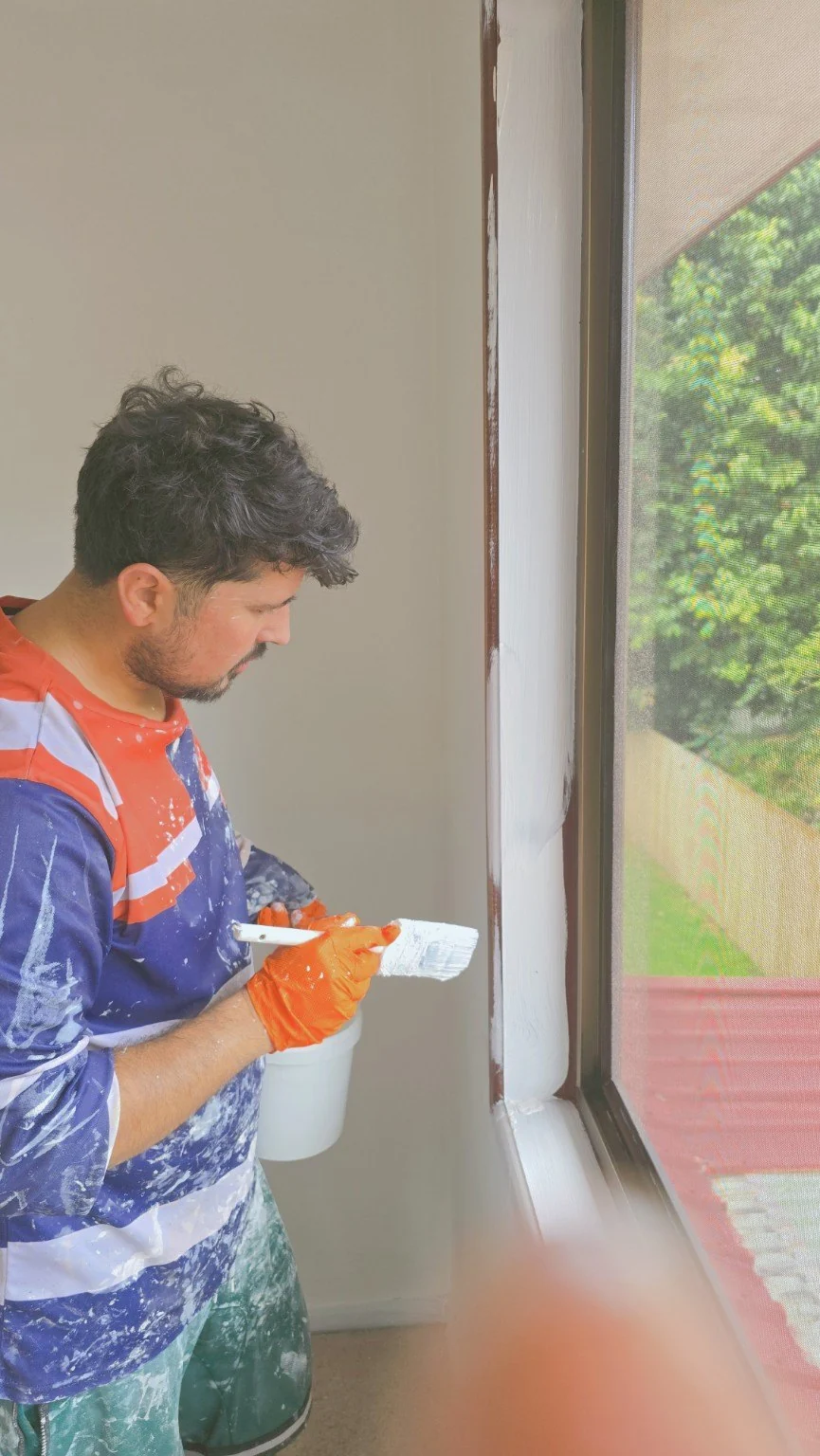 Careful brushwork around a window frame